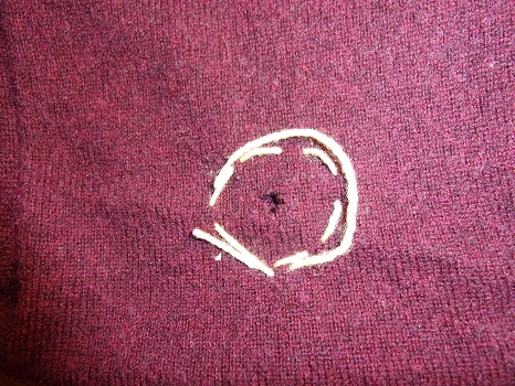 Pullover aus weinroter Merinowolle mit Loch