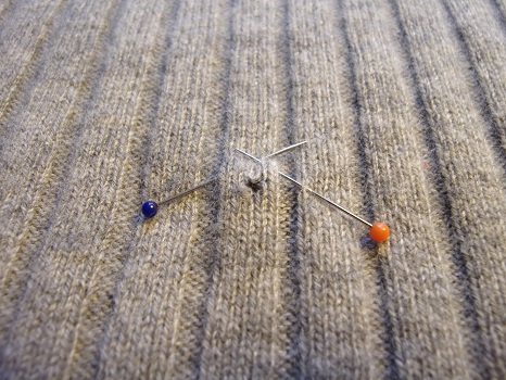 grauer Pullover mit Loch